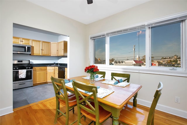 dining area featuring sink, hardwood / wood-style flooring, and ceiling fan