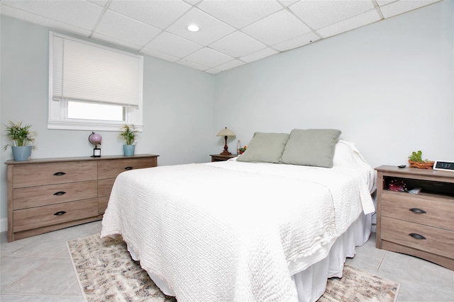 bedroom featuring a drop ceiling and light tile patterned flooring