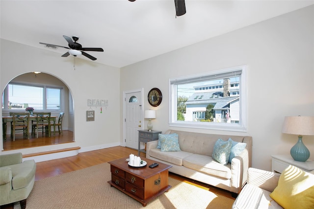 living room featuring ceiling fan, light hardwood / wood-style flooring, and a wealth of natural light