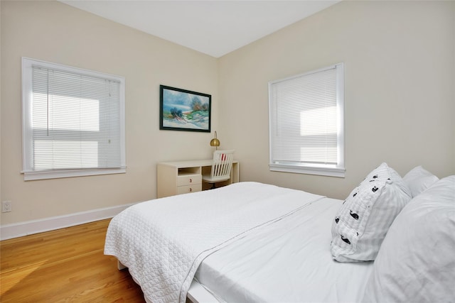 bedroom with multiple windows and wood-type flooring