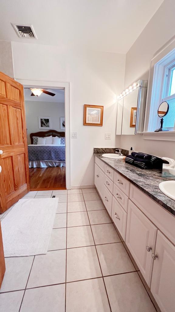 bathroom with tile patterned flooring, vanity, and ceiling fan