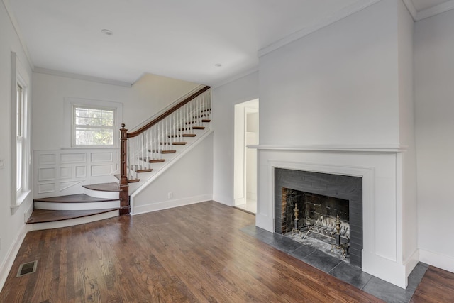 unfurnished living room with crown molding and dark wood-type flooring