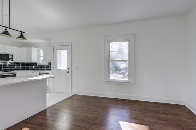 kitchen with white cabinetry, a healthy amount of sunlight, stainless steel appliances, and pendant lighting