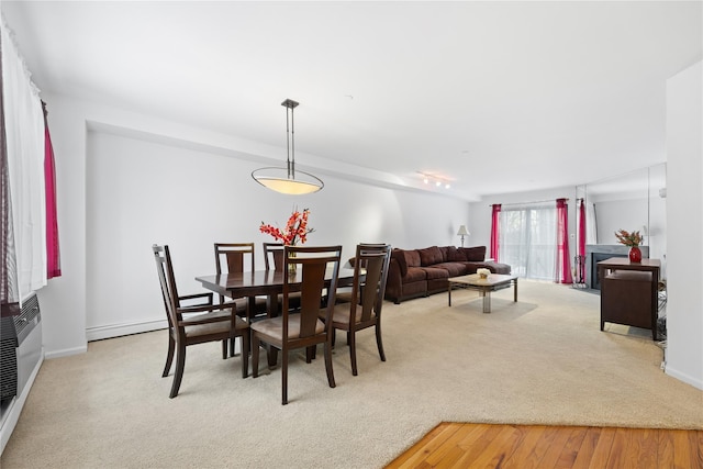 carpeted dining space featuring a baseboard radiator