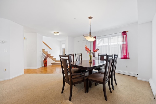 carpeted dining room with a baseboard heating unit