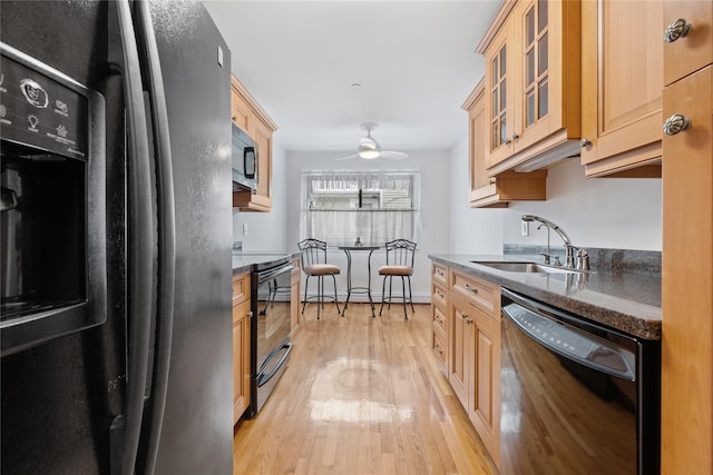 kitchen with light brown cabinetry, sink, ceiling fan, black appliances, and light wood-type flooring