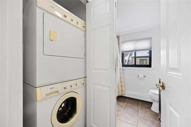 clothes washing area with stacked washer / dryer and light tile patterned floors