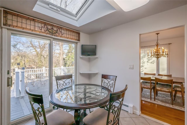 tiled dining room featuring a notable chandelier, baseboard heating, and a skylight