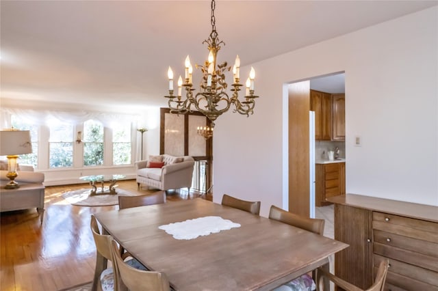 dining space with an inviting chandelier and light hardwood / wood-style floors