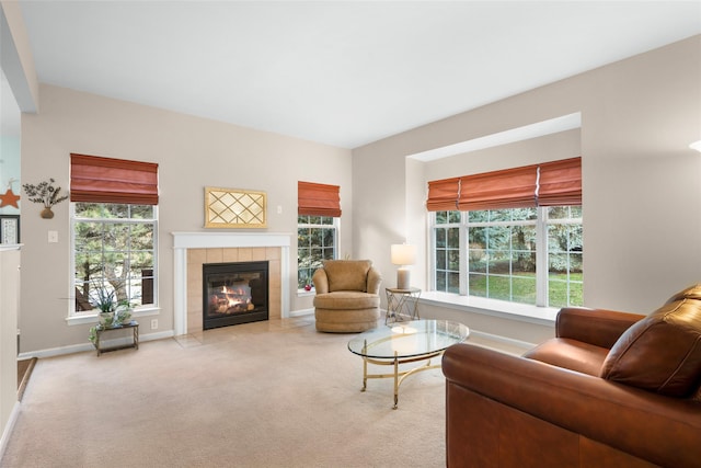 living room featuring a tiled fireplace and light colored carpet