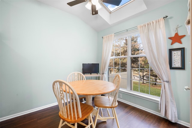 dining area featuring dark hardwood / wood-style floors, ceiling fan, lofted ceiling with skylight, and a wealth of natural light