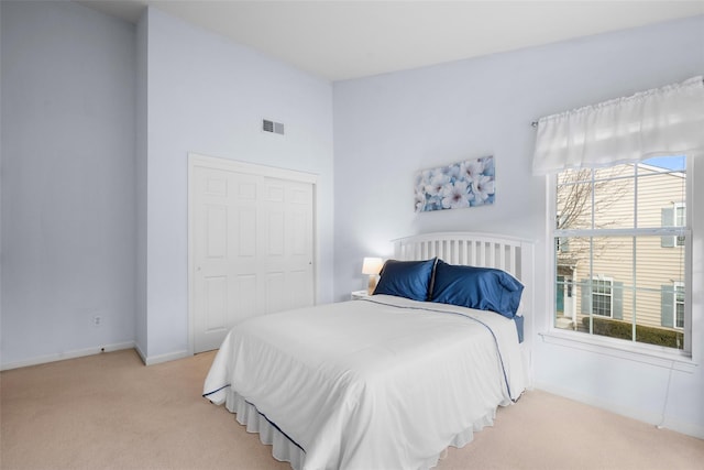 bedroom featuring light colored carpet and a closet