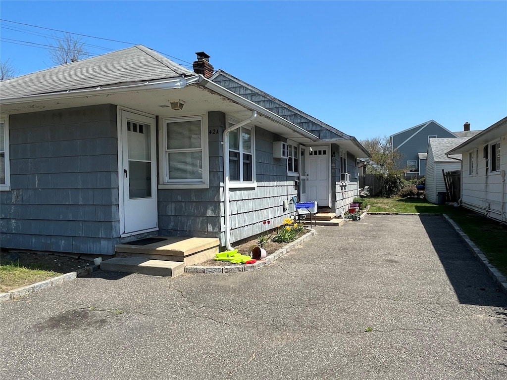 42 Firwood Rd, Port Washington, NY 11050 - view of front facade featuring a chimney and a shingled roof