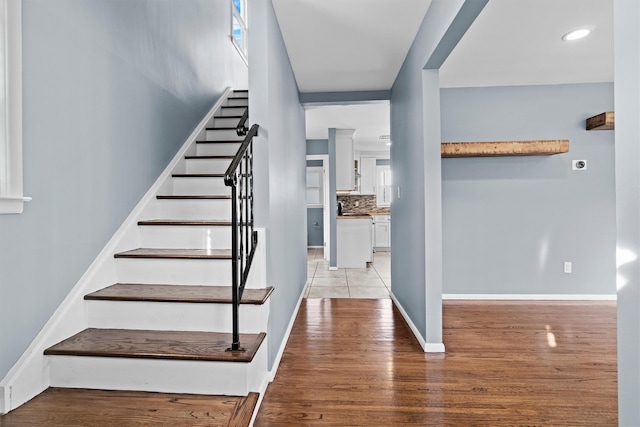 stairway with hardwood / wood-style floors and plenty of natural light