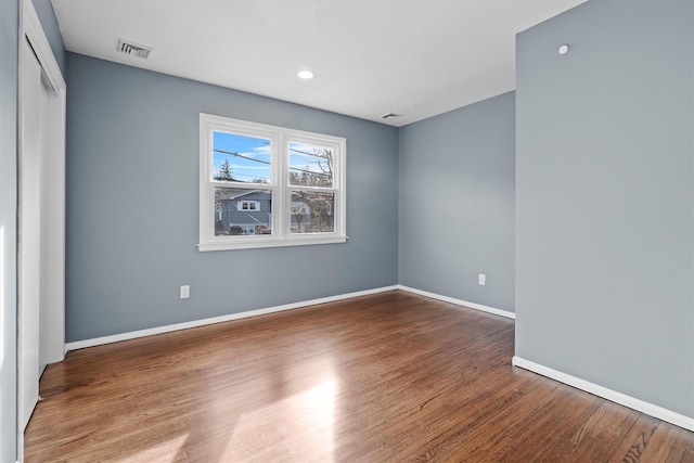 empty room with hardwood / wood-style flooring