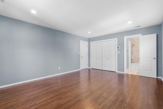 unfurnished bedroom featuring a closet and dark hardwood / wood-style floors