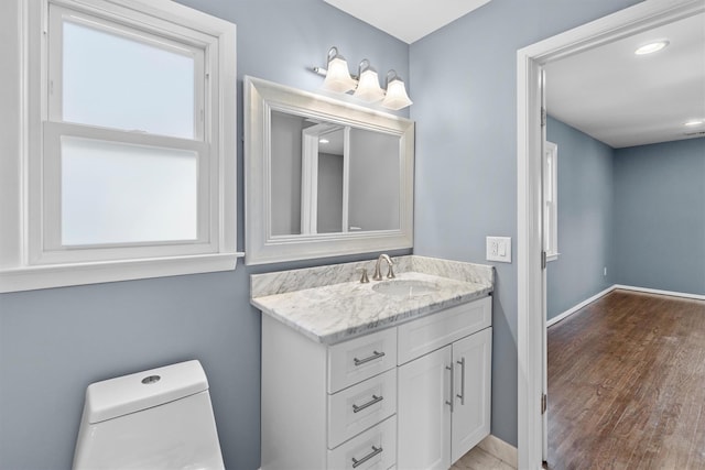 bathroom featuring vanity, wood-type flooring, and toilet