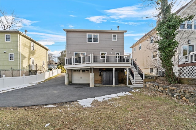 back of house with a garage and a deck