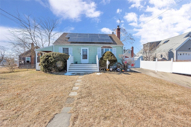 rear view of house with a lawn and solar panels