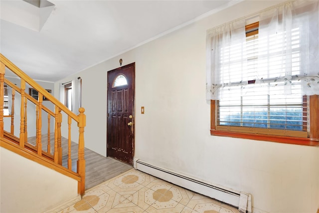 foyer with ornamental molding and a baseboard heating unit