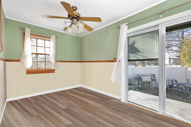 empty room featuring hardwood / wood-style flooring, ornamental molding, and ceiling fan