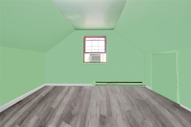 bonus room with cooling unit, light wood-type flooring, vaulted ceiling, and baseboard heating