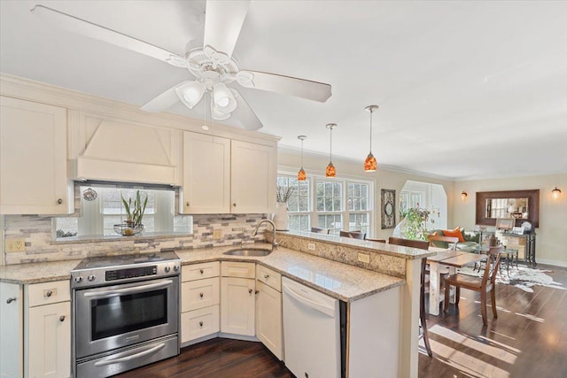 kitchen with stainless steel electric range oven, a sink, premium range hood, dishwasher, and a peninsula