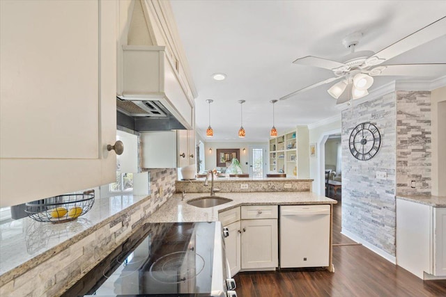 kitchen with crown molding, white dishwasher, a peninsula, and a sink