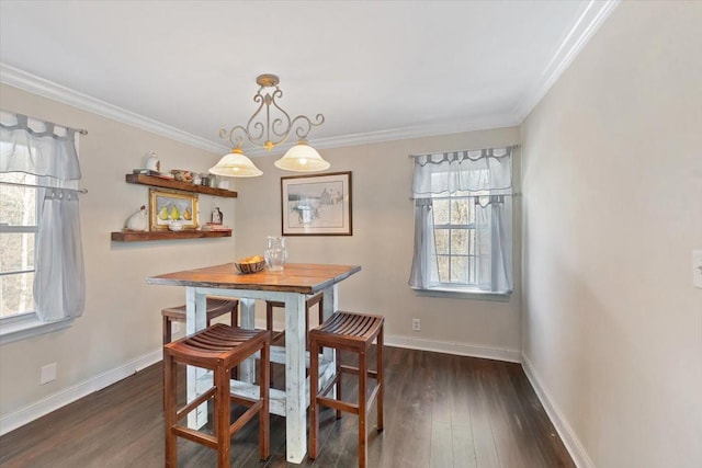 dining area with baseboards, ornamental molding, and wood finished floors