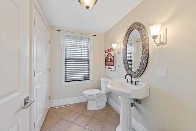 bathroom with baseboards, visible vents, toilet, and tile patterned floors