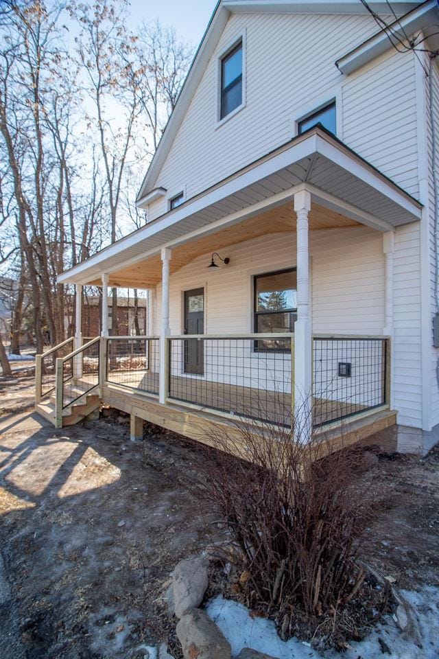 view of side of property featuring covered porch