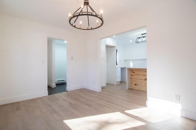 interior space featuring baseboard heating, a chandelier, and light hardwood / wood-style flooring