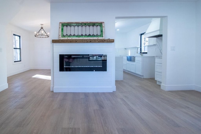 interior space featuring sink, a chandelier, hardwood / wood-style floors, and custom exhaust hood