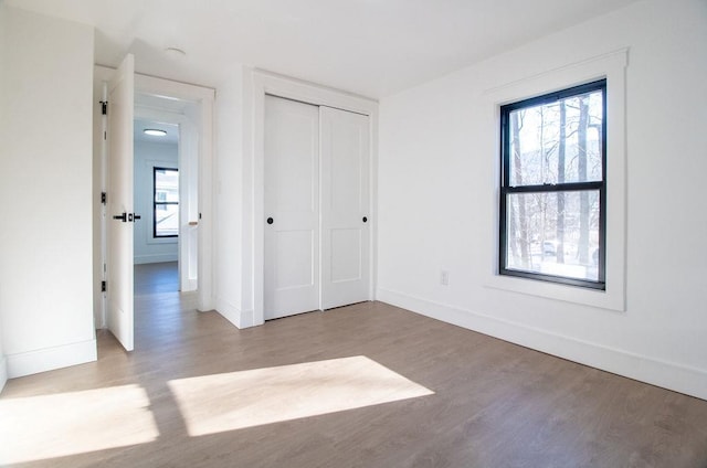 unfurnished bedroom featuring light hardwood / wood-style floors and a closet