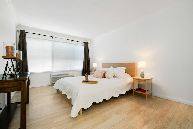 bedroom featuring a wall mounted AC and light hardwood / wood-style flooring