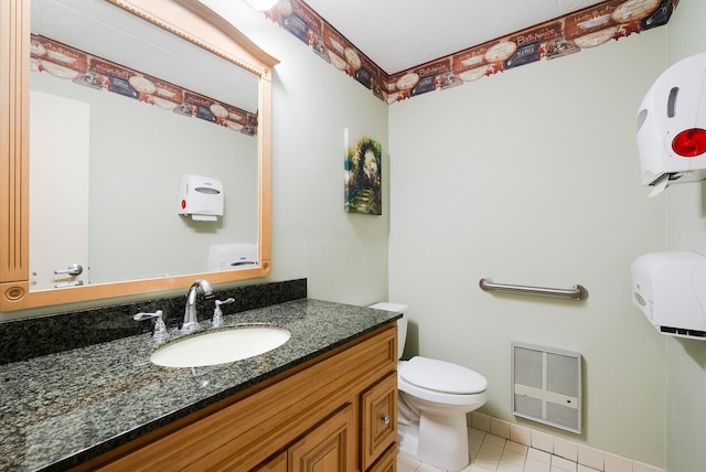 bathroom with vanity, heating unit, tile patterned floors, and toilet