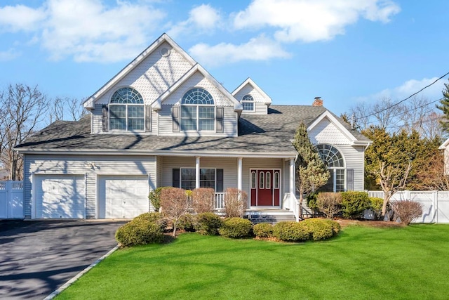 view of front facade featuring a front yard, a porch, driveway, and fence