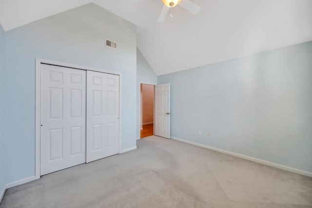 unfurnished bedroom with baseboards, visible vents, carpet floors, high vaulted ceiling, and a closet