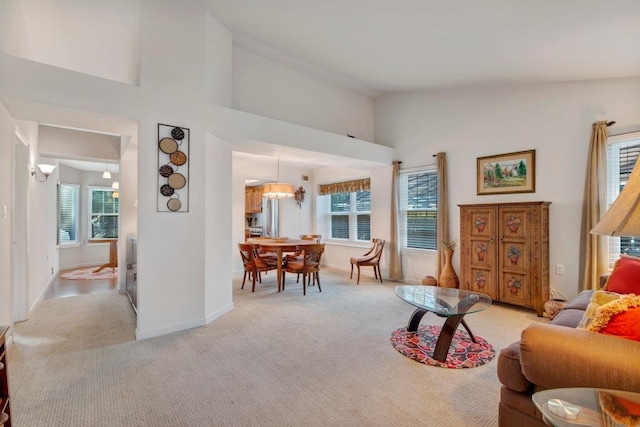 living room with a healthy amount of sunlight, light carpet, and high vaulted ceiling