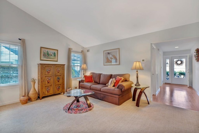 carpeted living room with high vaulted ceiling