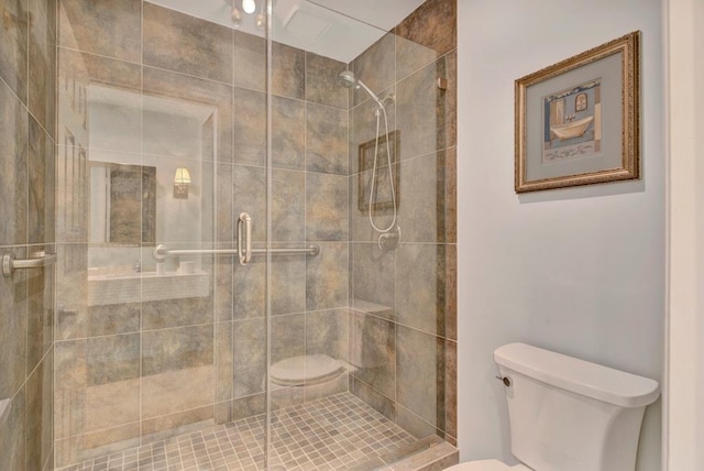 bathroom featuring toilet and a shower with shower door