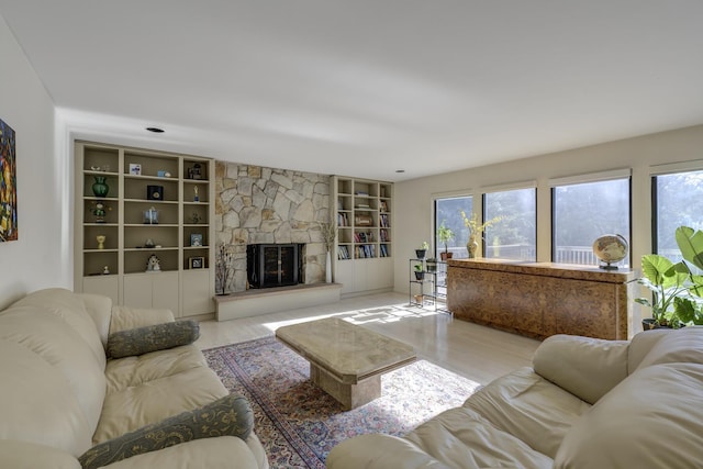 living room featuring a stone fireplace and light wood-type flooring