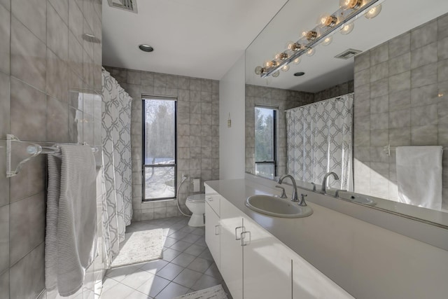 bathroom featuring tile walls, vanity, tile patterned floors, and toilet