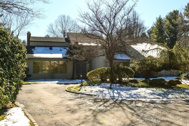 view of front of home featuring a chimney and stucco siding