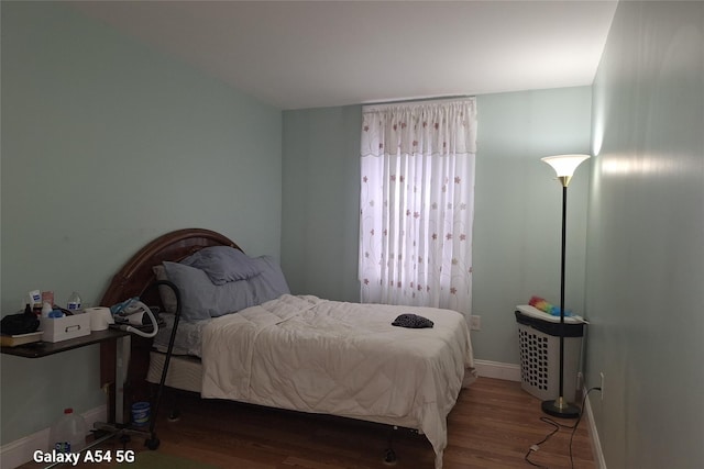 bedroom with dark hardwood / wood-style floors