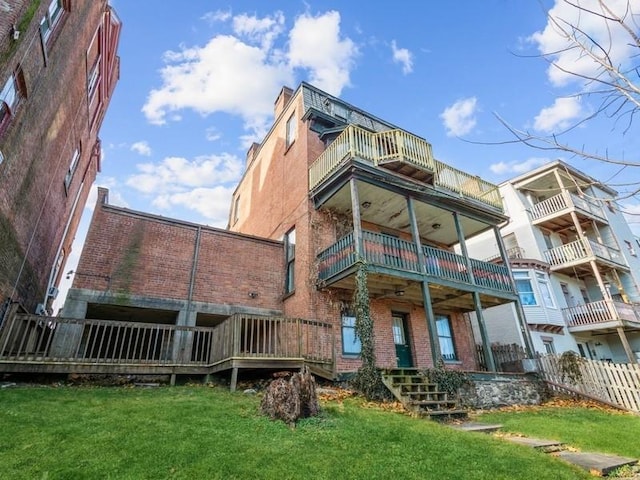 exterior space featuring a lawn and a balcony