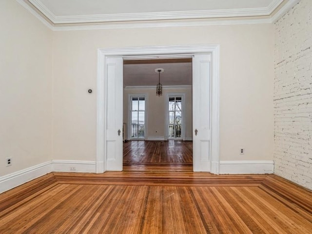 empty room with crown molding and wood-type flooring