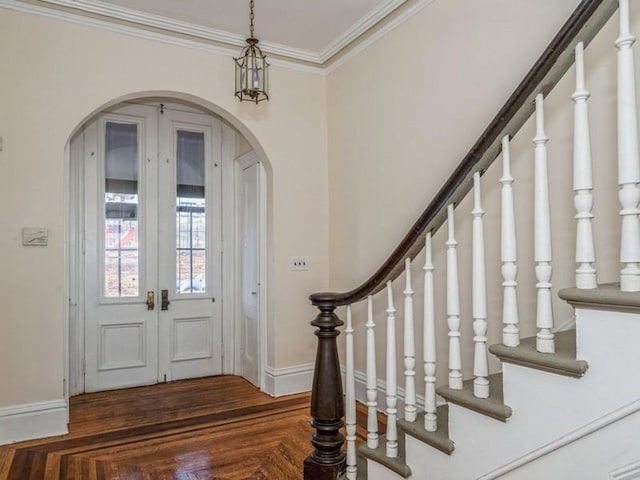 entryway featuring crown molding, dark parquet flooring, and french doors