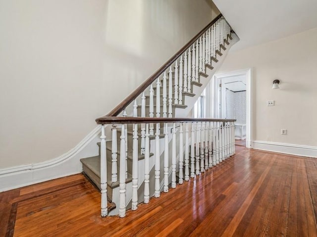 stairs featuring hardwood / wood-style flooring and a towering ceiling