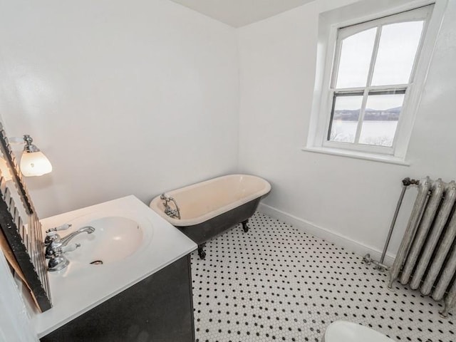 bathroom featuring radiator, a tub, vanity, toilet, and tile patterned floors